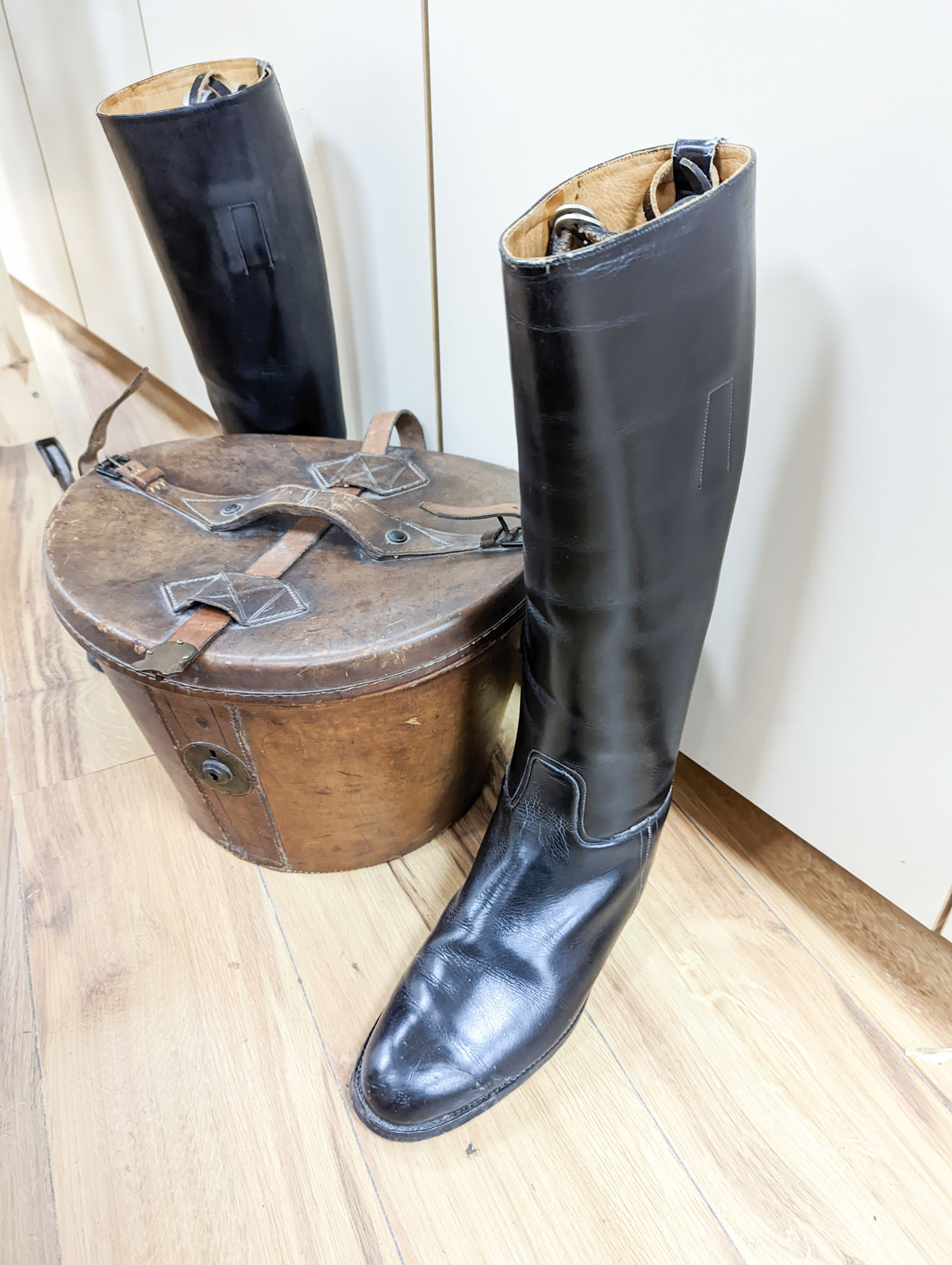 A gents 8 1/2 sized riding boots and a brown leather case for a top hat